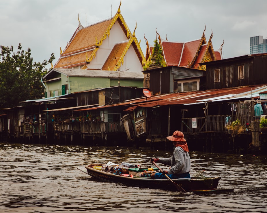 Лодка на реке в Таиланде на фоне домов